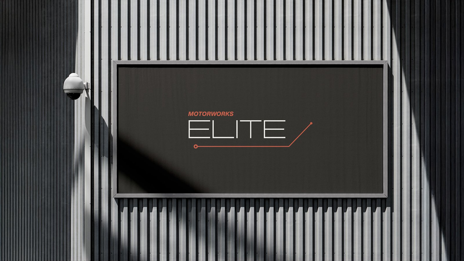 Motorworks ELITE billboard on a modern corrugated metal building facade, featuring minimalist logo design in white and orange.