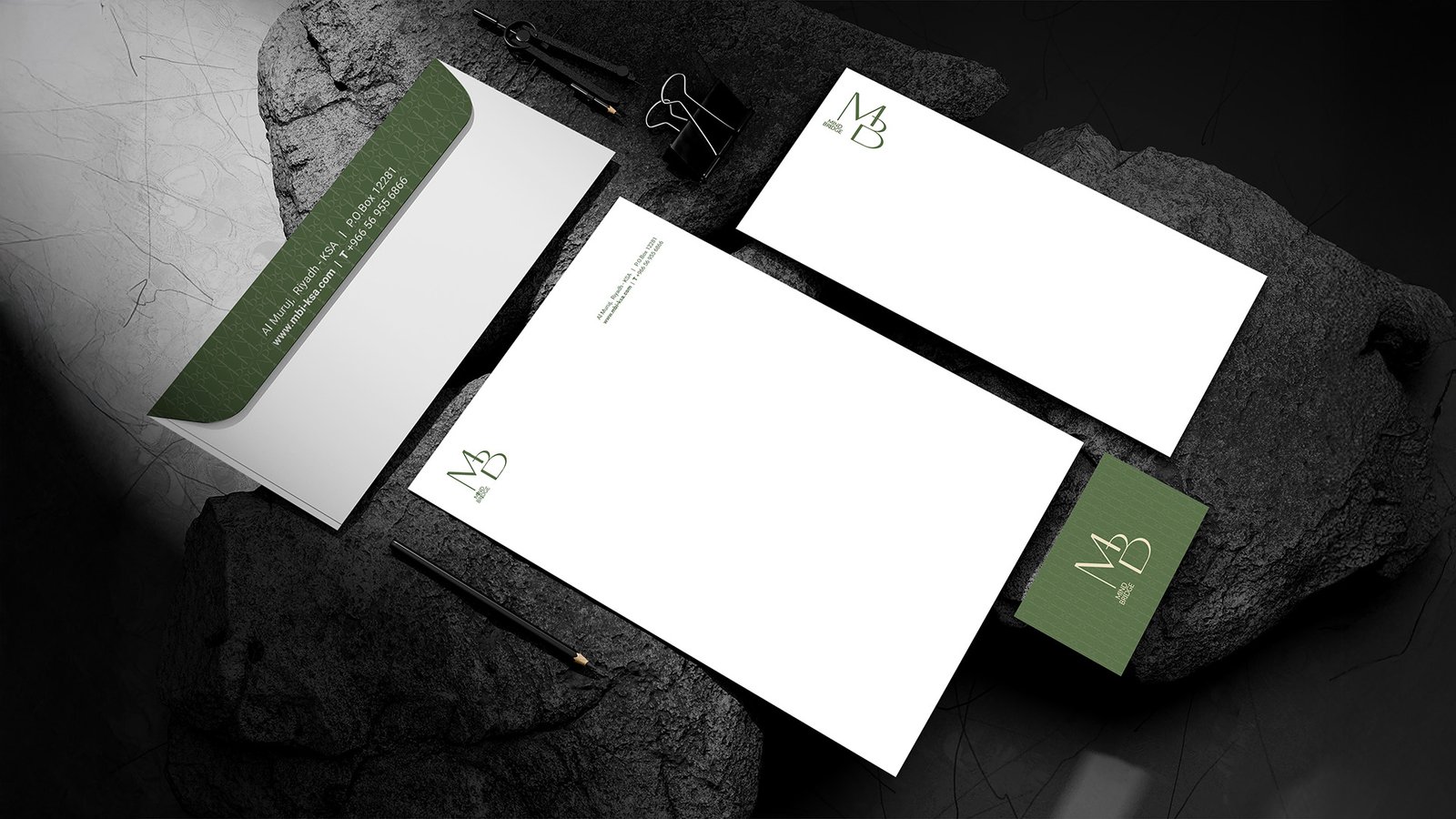 Mind Bridge branded stationery set including letterhead, envelope, and business card, placed on dark textured stone for a premium corporate identity presentation.